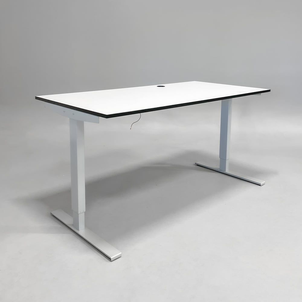 Begagnat höj- och sänkbart skrivbord med vit bordsskiva svart kant och silverfärgade ben. Mått: bredd 110 cm och djup 90 cm, Justerbar höjd 70 - 120 cm.