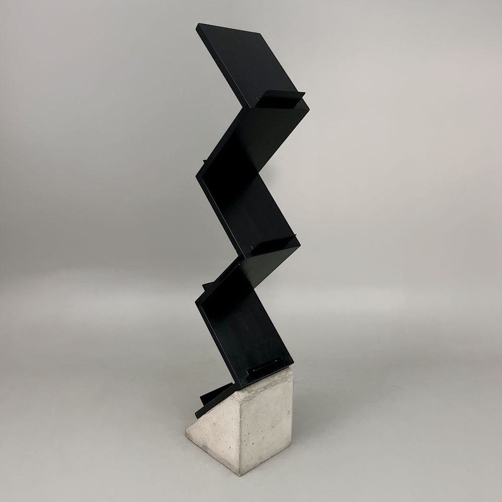 Begagnat tidskriftsställ Zink från Källemo i svart. I zick-zack design med betongfot. Mått: Bredd: 27 cm, djup 35 cm och höjd 155 cm.
