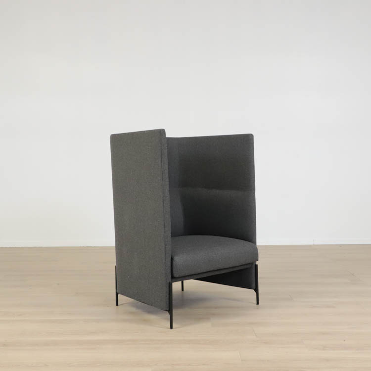 Begagnad fåtölj med hög rygg från Arflex. I mörkt grått tyg. Mått: bredd 81 cm, djup 74 cm, sittdjup 59 cm. Ryggen ger ökad komfort och privatliv.