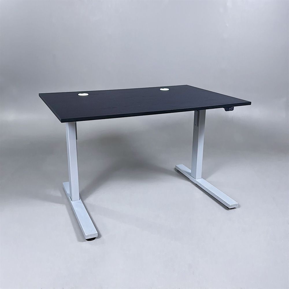 Begagnat höj- och sänkbart skrivbord med svart bordsskiva med två kabelhål, silvrigt stativ. Mått: Bredd 120 cm, Djup 80 cm, Höjd justerbar mellan 70 till 120 cm. 