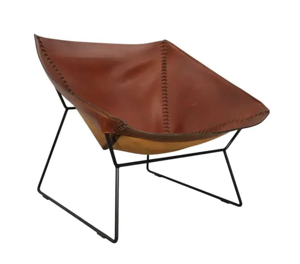 Begagnad fåtölj Stitch Chair från OX Denmarq. Klädd i brun anilinläder med en svart ram. Mått: Höjd 72 cm, Bredd 90 cm, Djup 85 cm, Sitthöjd: 36 cm.