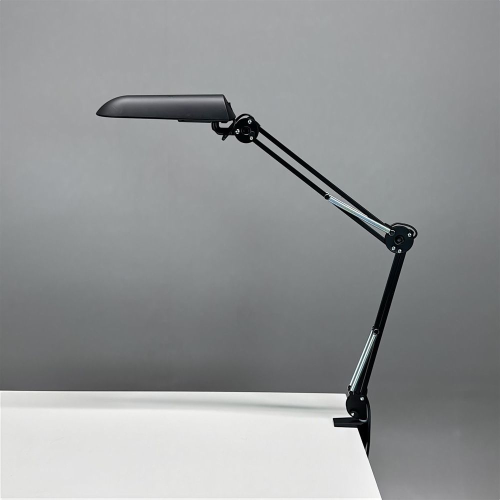 Begagnad skrivbordslampa Verit från Glamox Luxo med klämfäste i svart. Mått: höjd 85 cm.