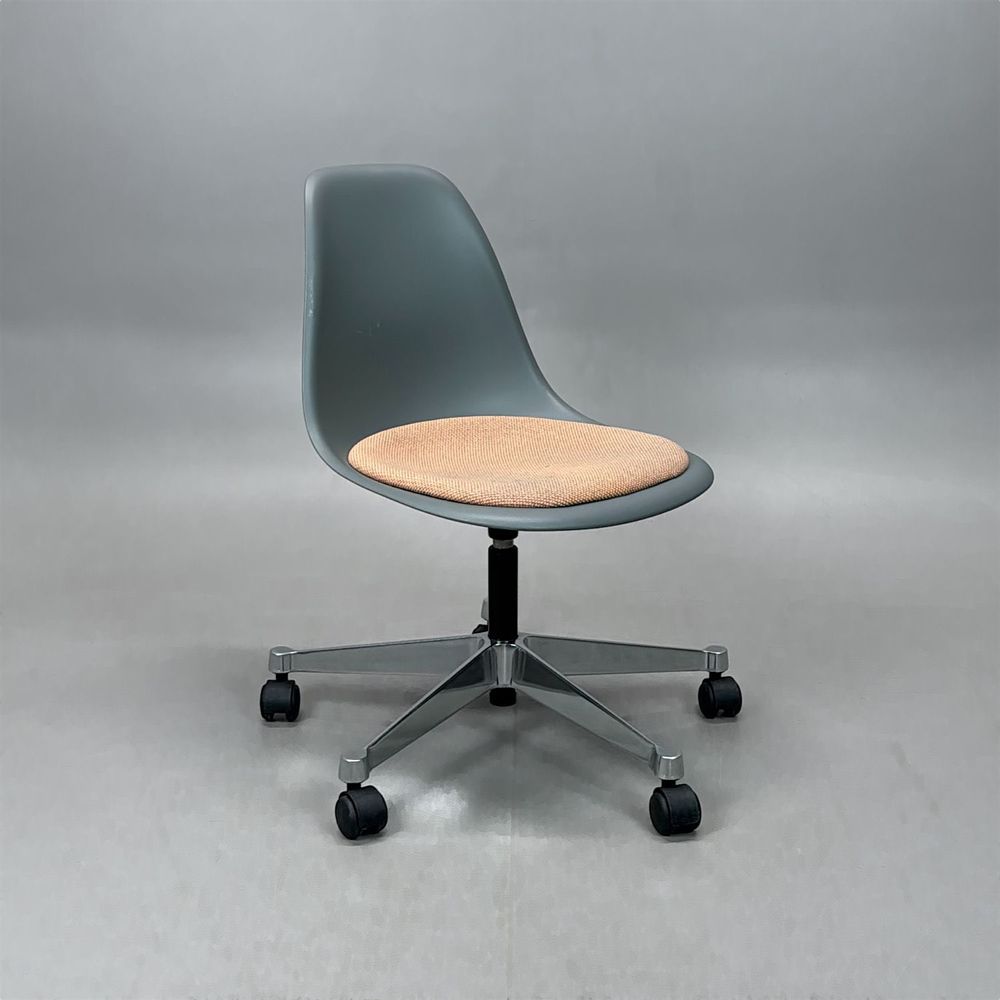Begagnad stol med hjul Eames Plastic Side Chair PSCC från Vitra. Grått plastskal, ljusrosa sittdyna, kromat underrede. Mått: Bredd 46,5 cm, Djup 55 cm, Höjd 76-88,5 cm. 