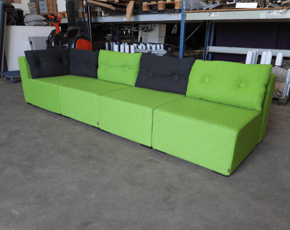 Begagnad modulsoffan Monolog från Materia är klädd i grön textil, med kuddar i grönt och grått. Mått: Bredd 300 cm, djup 90 cm, höjd 65 cm, sitthöjd 38 cm.  