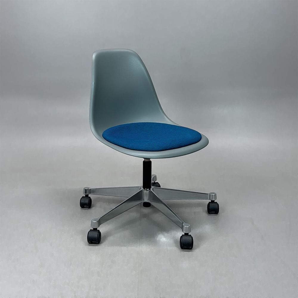 Begagnad stol med hjul Eames Plastic Side Chair PSCC från Vitra med grått plastskal, blå sittdyna, kromat underrede. Mått: Bredd 46,5 cm, djup 55 cm, höjd 76–88,5 cm.