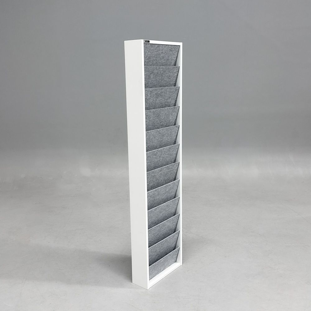 Begagnat broschyrställ Ridå från Karl Andersson & Söner. Vit stomme, fack i grå formfilt. Mått: bredd 37 cm, djup 12.5 cm och höjd 157.5 cm. 