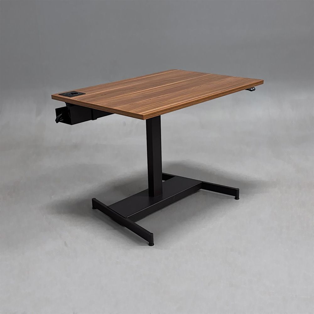 Begagnat höj och sänkbart skrivbord med bordsskiva i laminat finish av valnöt, stativ i svart. Mått: bredd 100 cm, djup 70 cm, justerbar höjd mellan 64 till 115 cm.