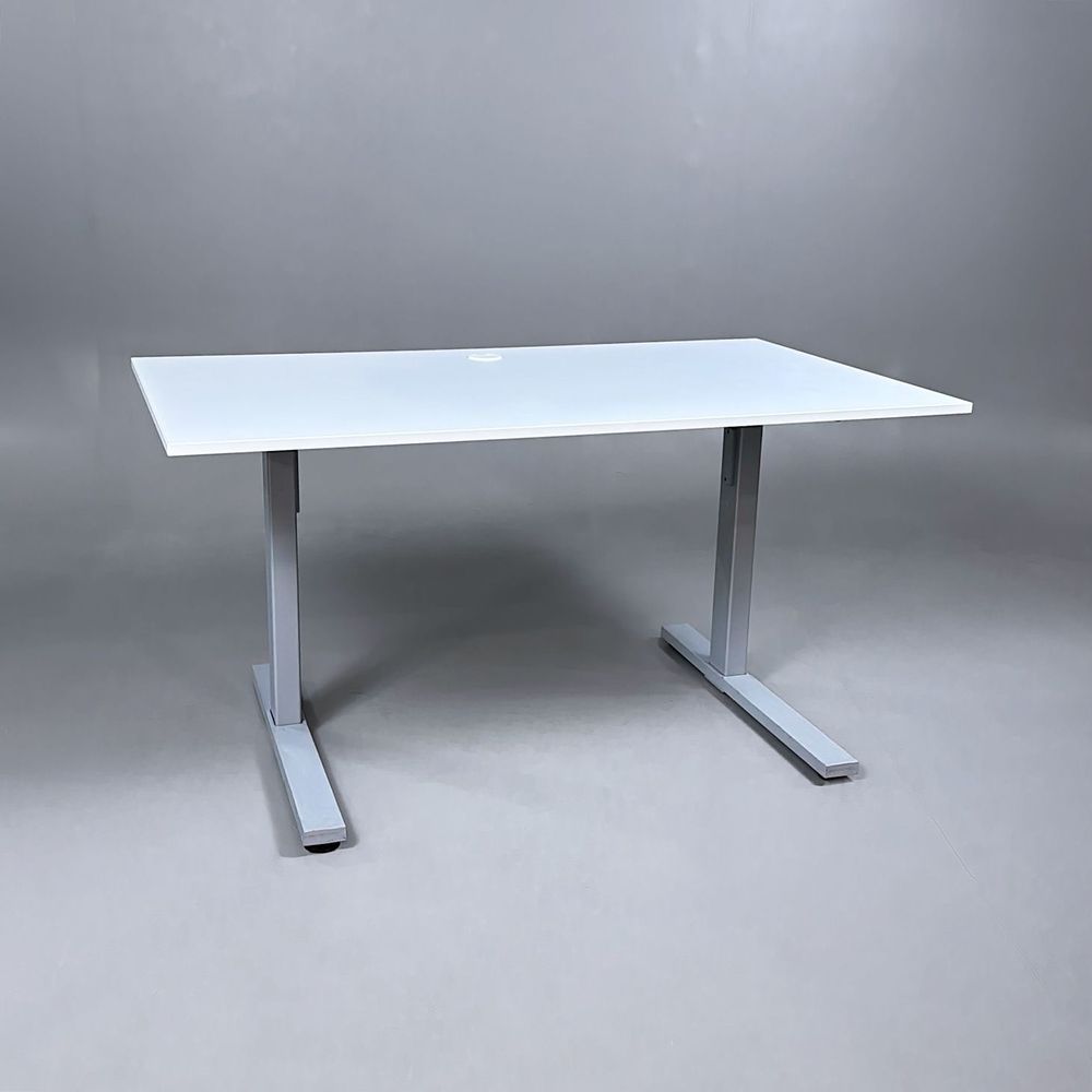 Begagnat höj och sänkbart skrivbord med vit bordsskiva och silverstativ. Mått: Bredd 140 cm, Djup 80 cm, Höjd justerbar mellan 70 cm till 120 cm. 