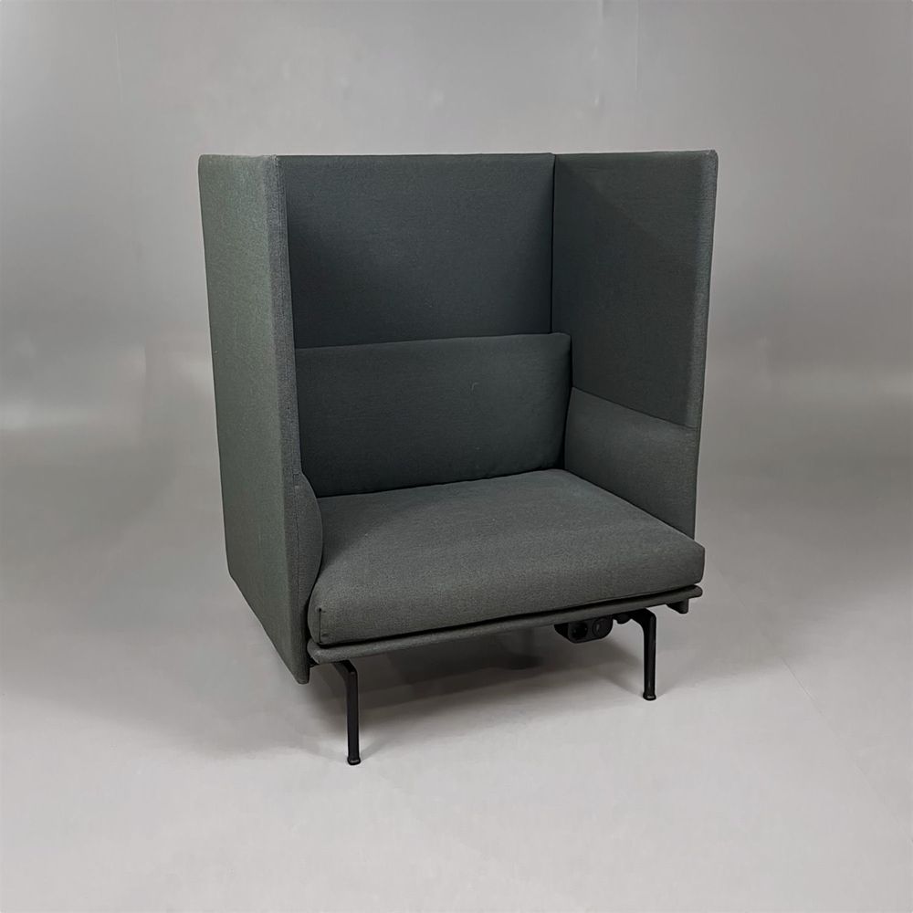 Begagnad Outline Highback från Muuto i mörkgrå tygklädsel, svarta ben, eluttag och USB-anslutningar. Mått: Bredd 88 cm, djup 76 cm, höjd 100 cm, sitthöjd 40 cm. 