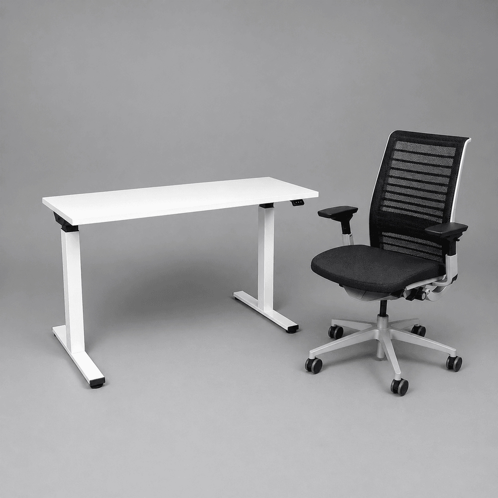 Begagnad kontorsgrupp från Steelcase med kontorsstol Think i mörkgrå/svart och höj-och sänkbart skrivbord Migration i vitt. Bredd 120 cm, Djup 60 cm. 