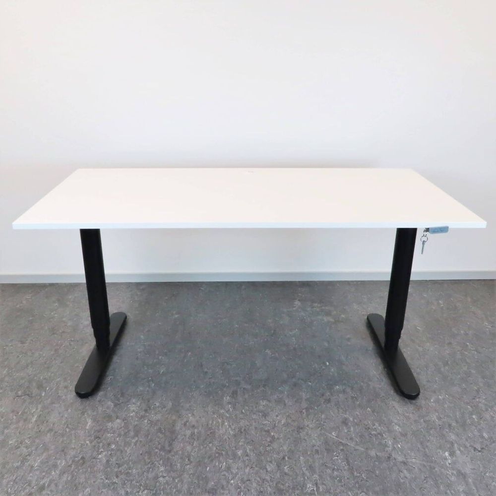 Begagnat höj-och sänkbart skrivbord Bekant från IKEA. Med vit bordsskiva och svart stativ. Mått: bredd 160 cm, djup 80 cm samt justerbar höjd 70 cm - 120 cm.