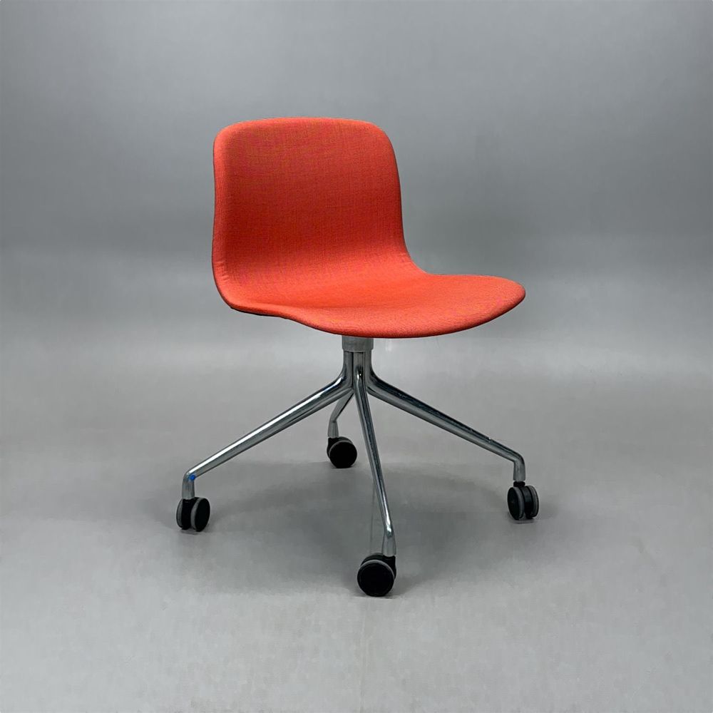 Begagnad stol med hjul AAC15 från HAY. Med tegelröd tygklädsel och kromat kryssunderrede. Mått: Bredd 51 cm, djup 52 cm, höjd 77 cm och sitthöjd 46 cm. 