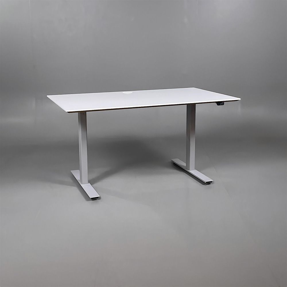 Begagnat höj- och sänkbart skrivbord med vit färgad bordsskiva och silvrigt stativ. Mått: Bredd 140 cm, djup 80 cm, justerbar höjd från 70 till 120 cm. 