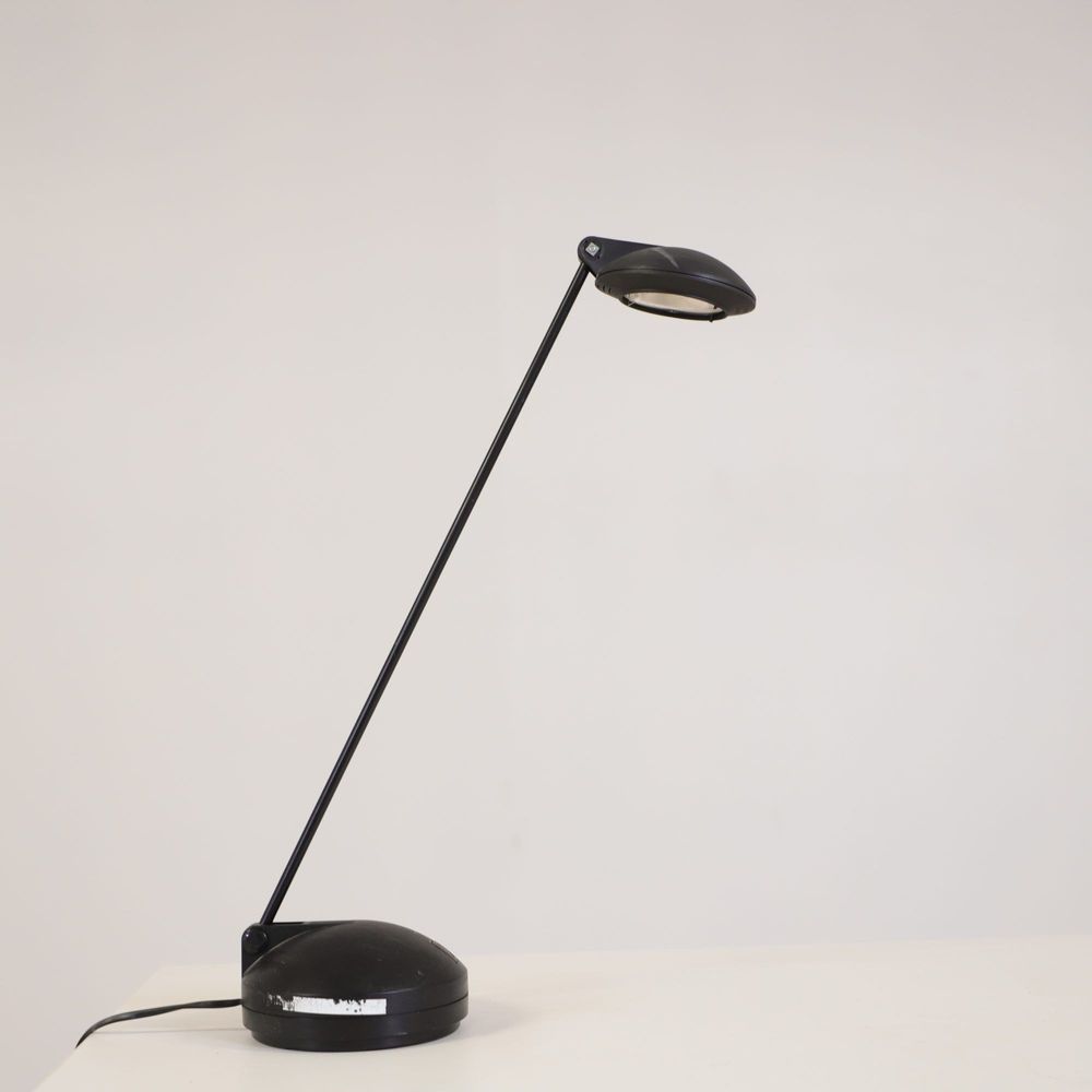 Begagnad skrivbordslampa Joker från Unilux i svart. Mått: Höjd 60 cm, fotens bredd 15 cm.