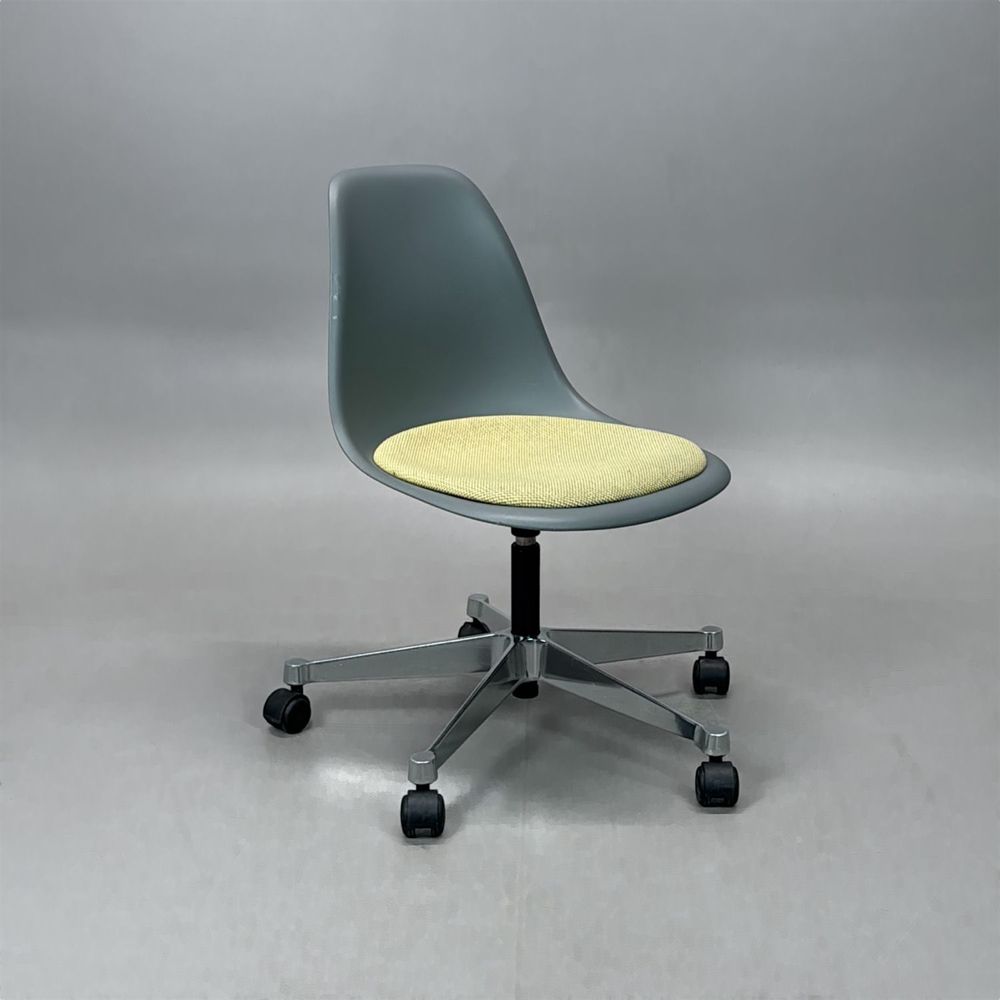 Begagnad Vitra Eames Plastic Side Chair PSCC med grått plastskal, ljusgul sittdyna, kromat underrede och hjul. Mått: Bredd 46,5 cm, djup 55 cm, höjd 76–88,5 cm.