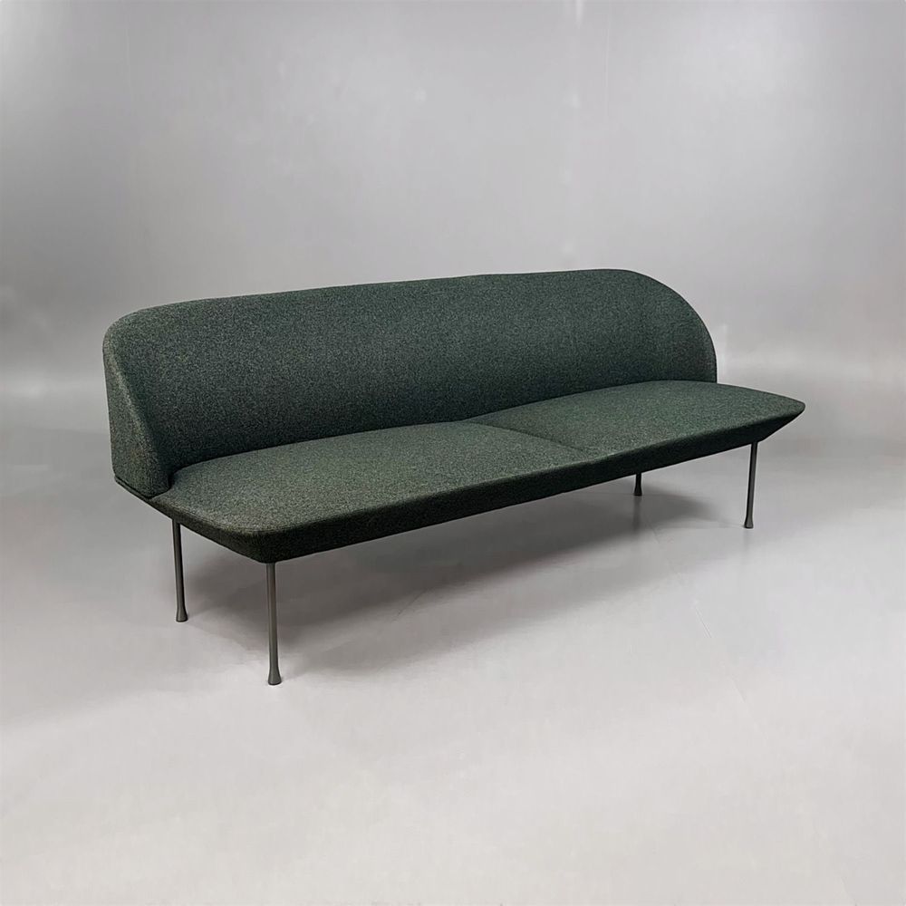 Begagnad soffa Oslo från Muuto. Klädsel i djupt mörkgrön tyg, ben i svart metall. Mått: bredd 200 cm, djup 73 cm och höjd 78 cm.