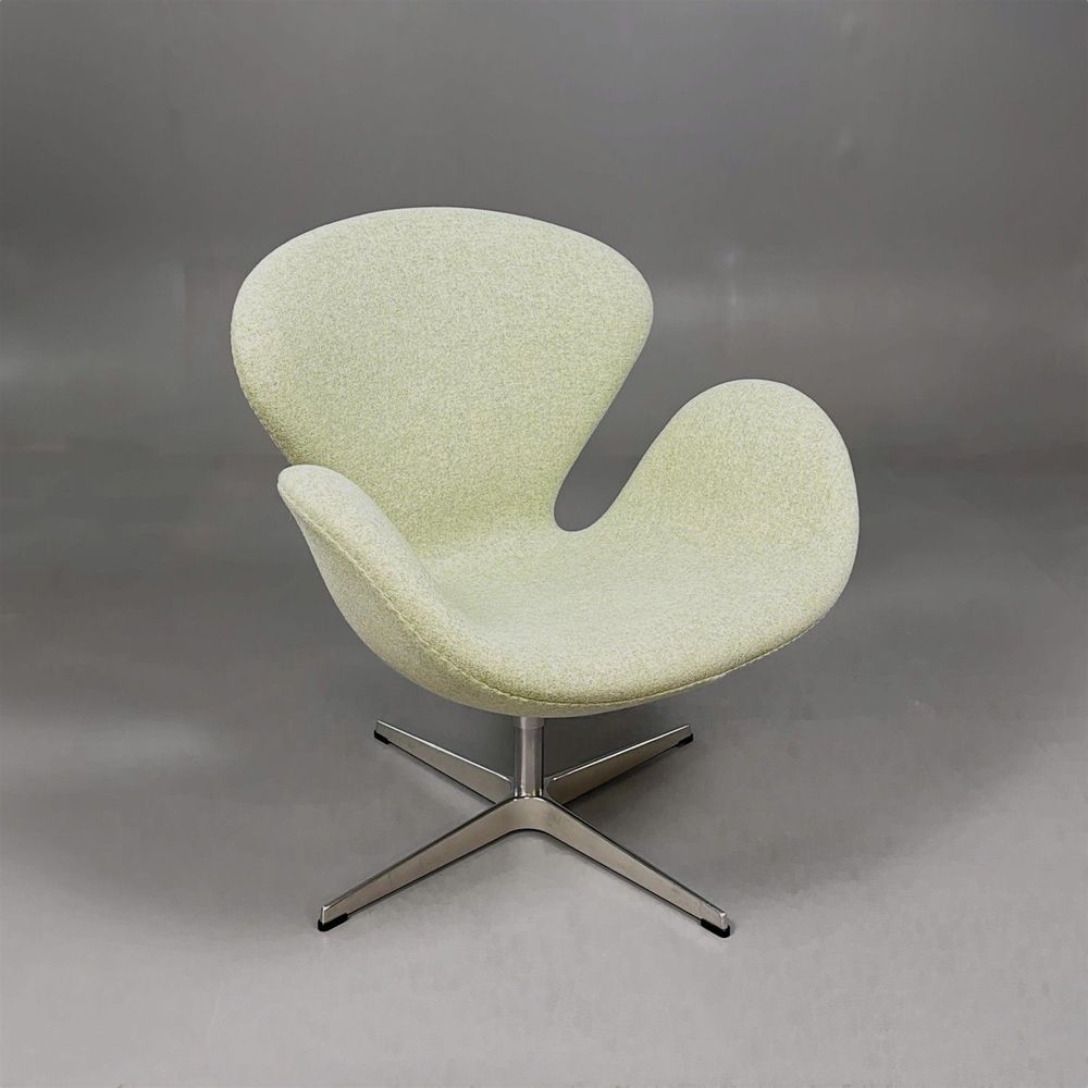 Begagnad fåtölj Svanen från Fritz Hansen i ljusgrönt tyg. Mått: bredd 74 cm, djup 68 cm och höjd 77 cm. 