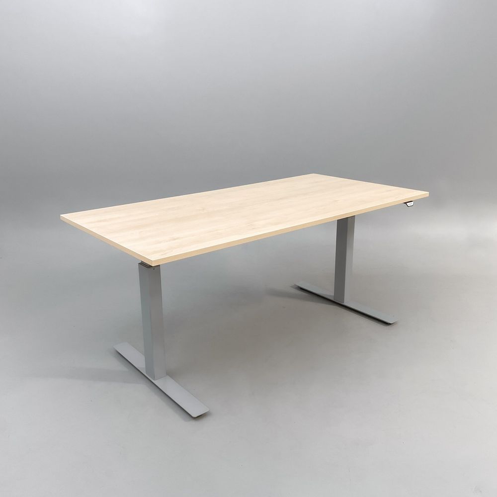Begagnat höj & sänkbart skrivbord med bordsskiva i björk och stativ i silver. Mått: bredd 160 cm, djup 80 cm, höjd 70 till 120 cm.