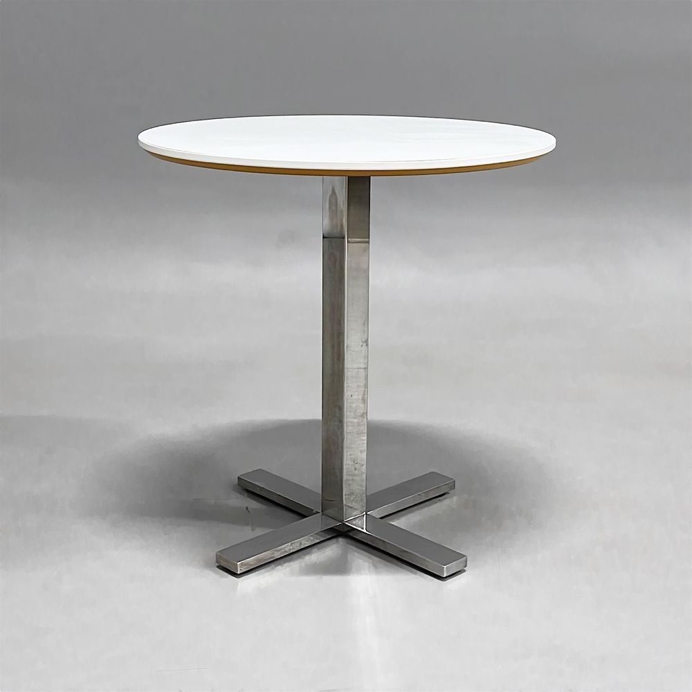 Begagnat cafébord från SA Möbler, modell Snitsa. Med en vit rund skiva och en kromad kryssfot. Höjd är 72 cm och diametern är 70 cm.
