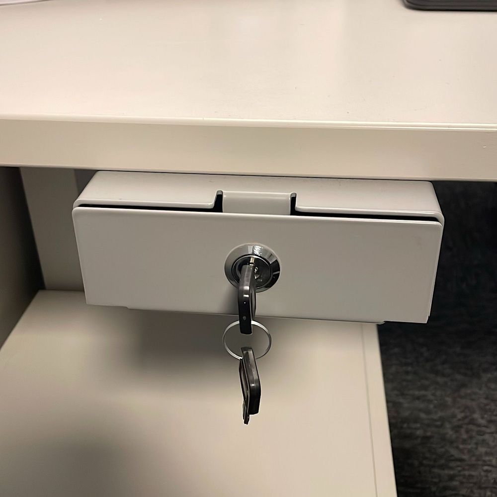 Begagnad Götessons pennlåda i ljusgrå färg erbjuder en smidig utdragsfunktion och säker låsanordning. Perfekt för effektiv organisering av kontorsmaterial. Bredd: 14 cm, Djup: 40 cm, Höjd: 5.1 cm.