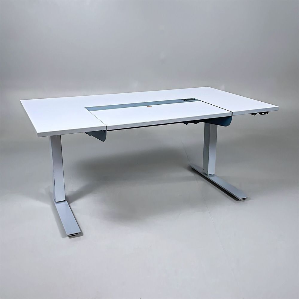 Begagnat höj- och sänkbart skrivbord Dynadesk från Work Motions. Bordsskiva i grå/vit. Mått: Bredd 140 cm, djup 80 cm, justerbar höjd från 70 till 120 cm. 