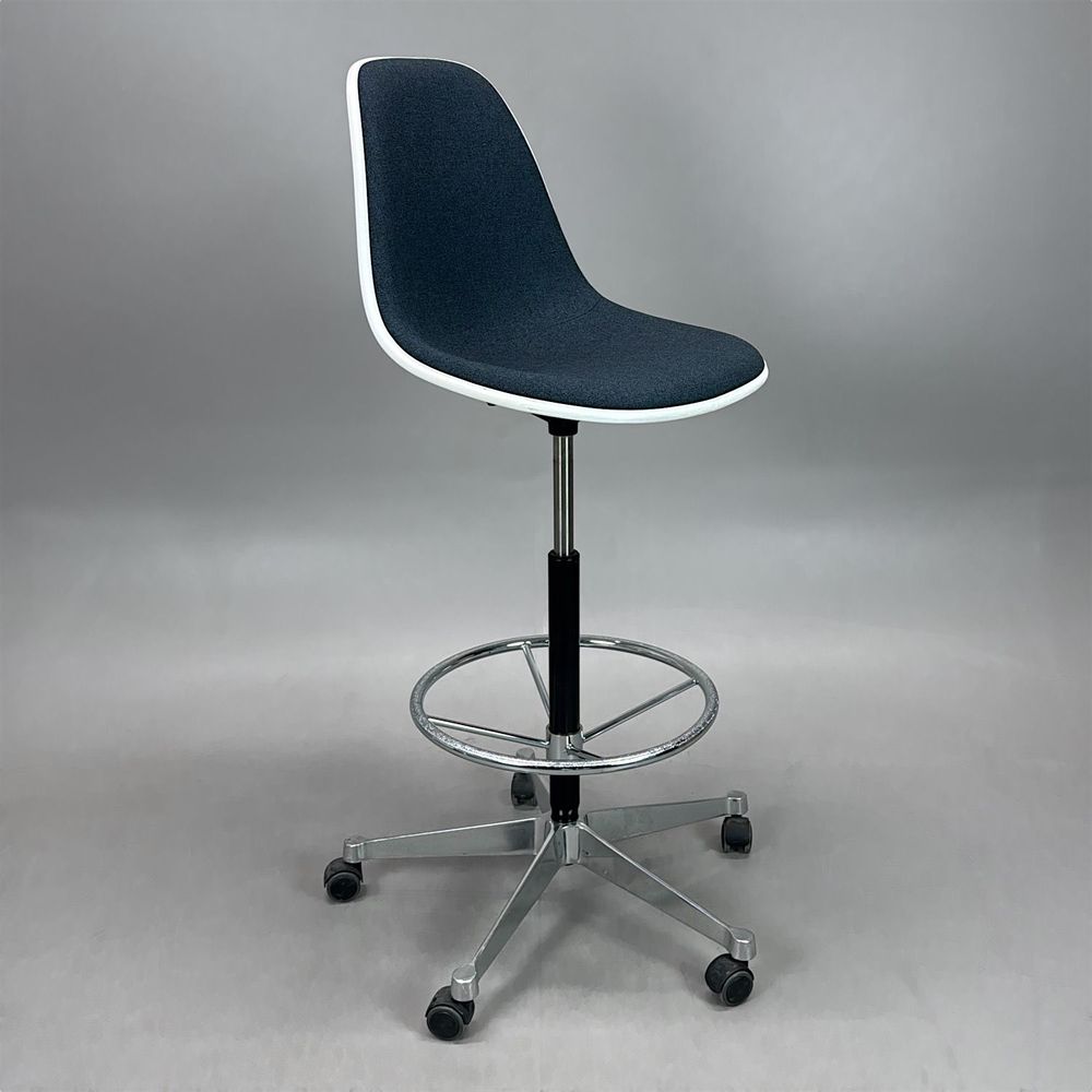 Begagnad stol med hjul Eames Plastic Side Chair PSCC från Vitra. Med blå klädsel, vit sitsskål och kromat underrede. Mått: Justerbar sitthöjd 74 - 86 cm.