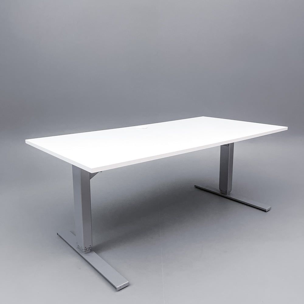 Begagnat höj och sänkbart skrivbord i vitt med stativ i silver, och kabeldike. Mått: bredd 160 cm, djup 80 cm, justerbar höjd 70 - 120 cm.
