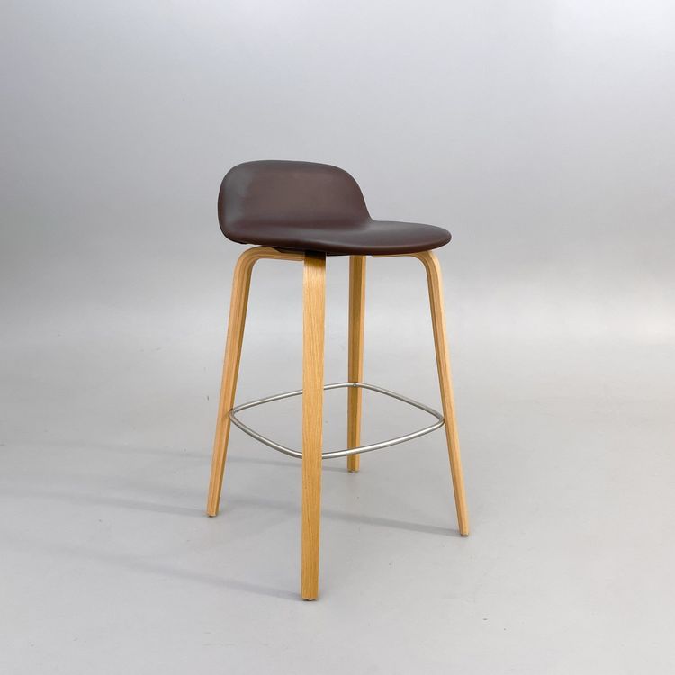 Begagnad barstol Visu från Muuto med sits i brunt skinn, ben i ek. Mått: bredd 41.3 cm, djup 40.1 cm, höjd 79 cm, sitthöjd 65 cm.