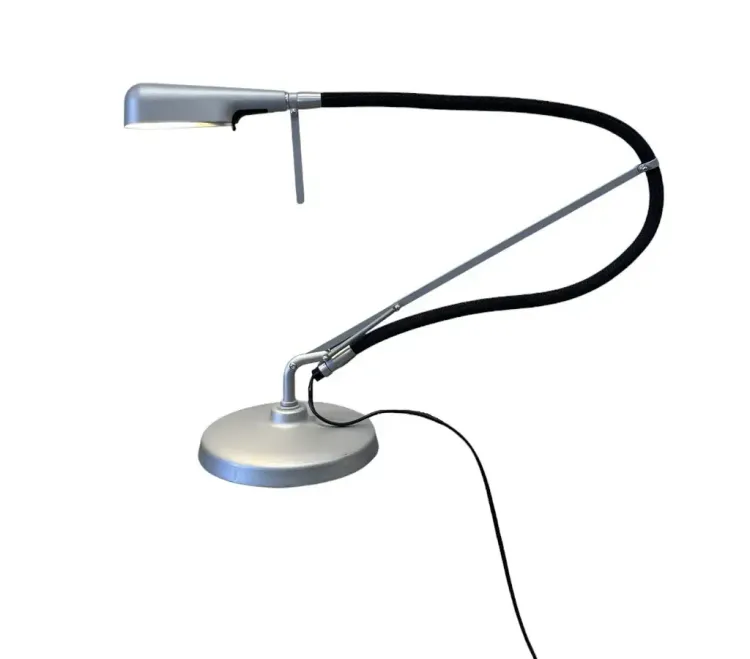 Begagnad skrivbordslampa Arketto från Glamox Luxo. Grålackad lampa med svartklädd arm. Mått: Höjd 97 cm, Bredd 60 cm, Djup 60 cm. 