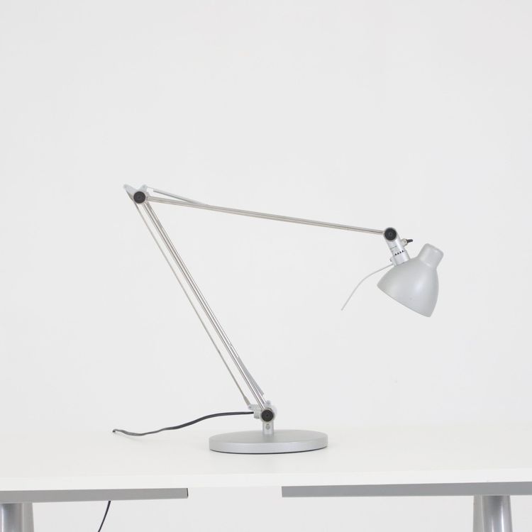 Begagnad skrivbordslampa Antifoni från IKEA i grått. Mått: justerbar höjd. Höjd 90 cm, fotens diameter 14 cm och lampans diameter 10 cm. 