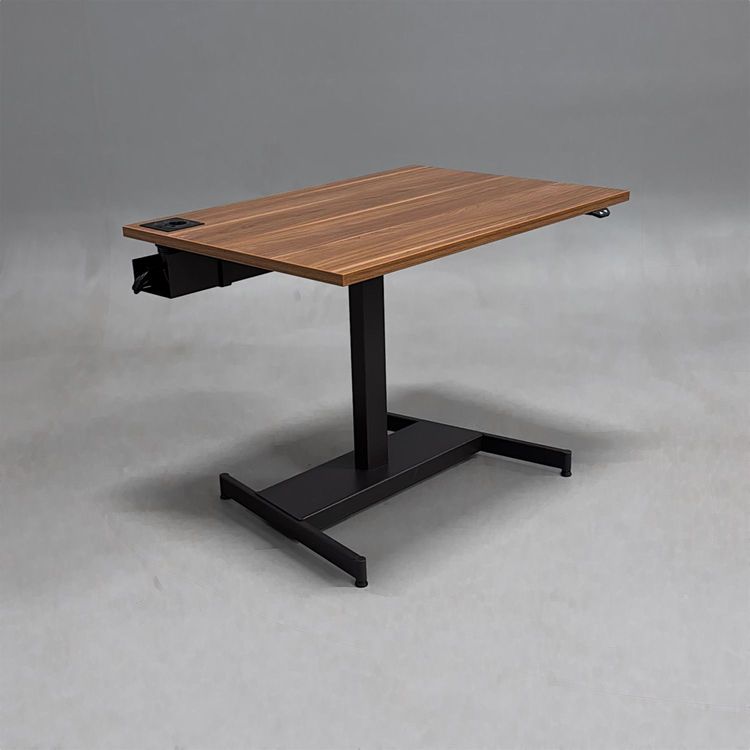 Begagnat höj och sänkbart skrivbord med bordsskiva i laminat finish av valnöt, stativ i svart. Mått: bredd 100 cm, djup 70 cm, justerbar höjd mellan 64 till 115 cm.