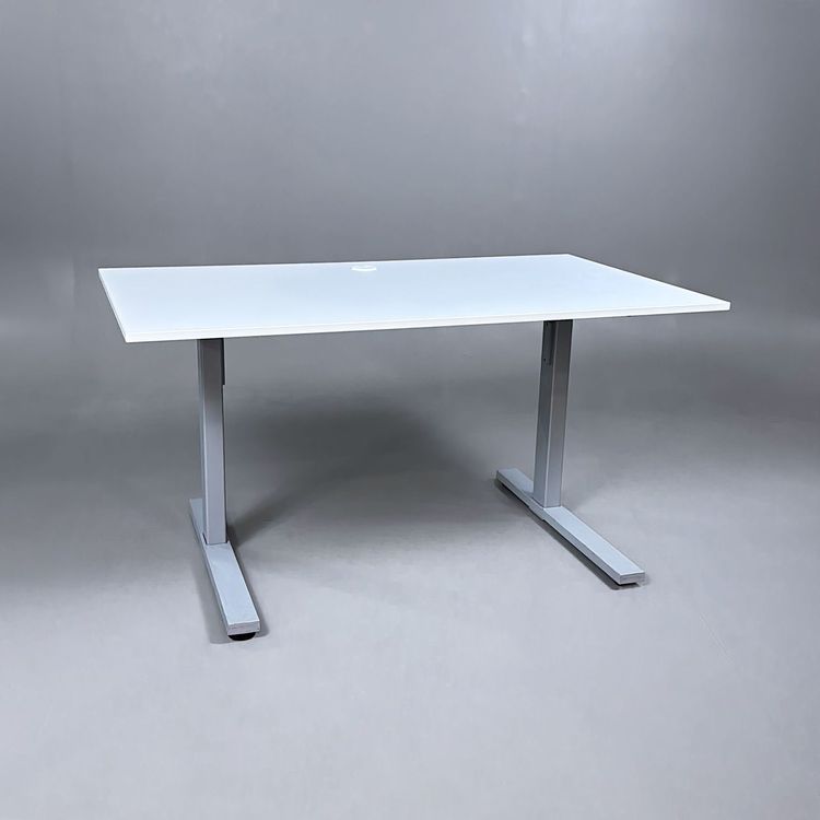 Begagnat höj och sänkbart skrivbord med vit bordsskiva och silverstativ. Mått: Bredd 140 cm, Djup 80 cm, Höjd justerbar mellan 70 cm till 120 cm. 