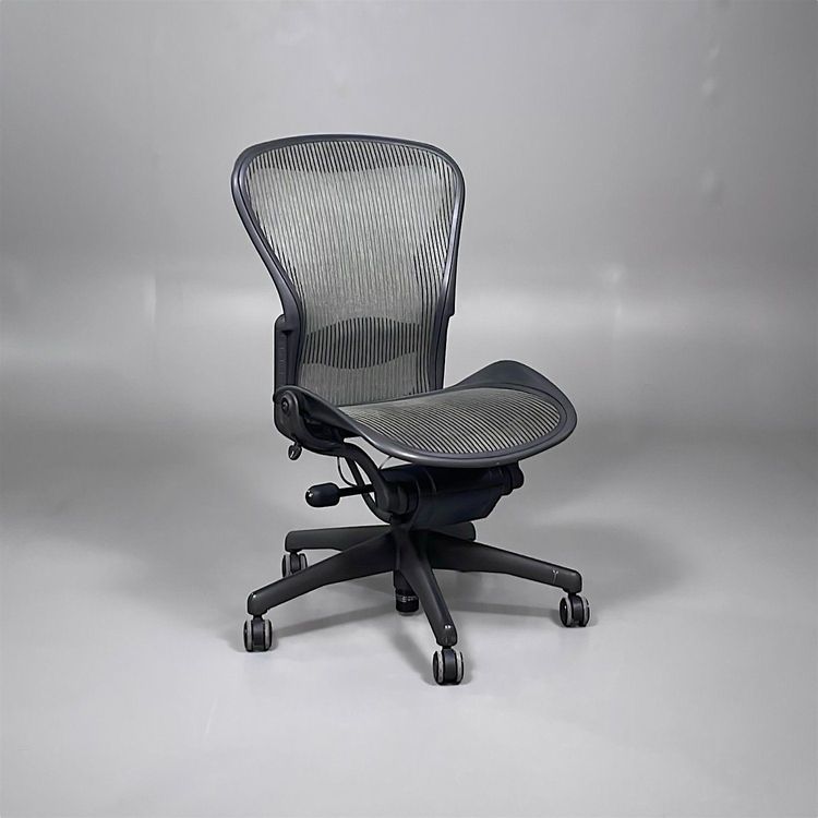 Begagnad kontorsstol utan armstöd från Herman Miller, modell Aeron B. Med meshrygg och sits i beige och svart, med justerbar sitthöjd mellan 40 till 60 cm. 