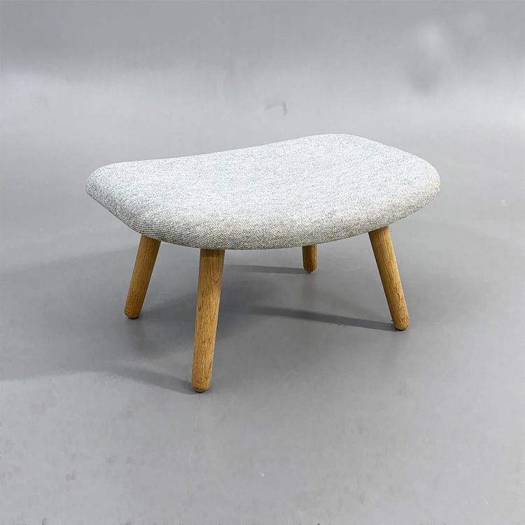 En begagnad grå fotpall/sittpuff AAL03 Ottoman från HAY i ljusgrått och ben av ek. Mått: bredd 66 cm, djup 50 cm och höjd 32 cm.  