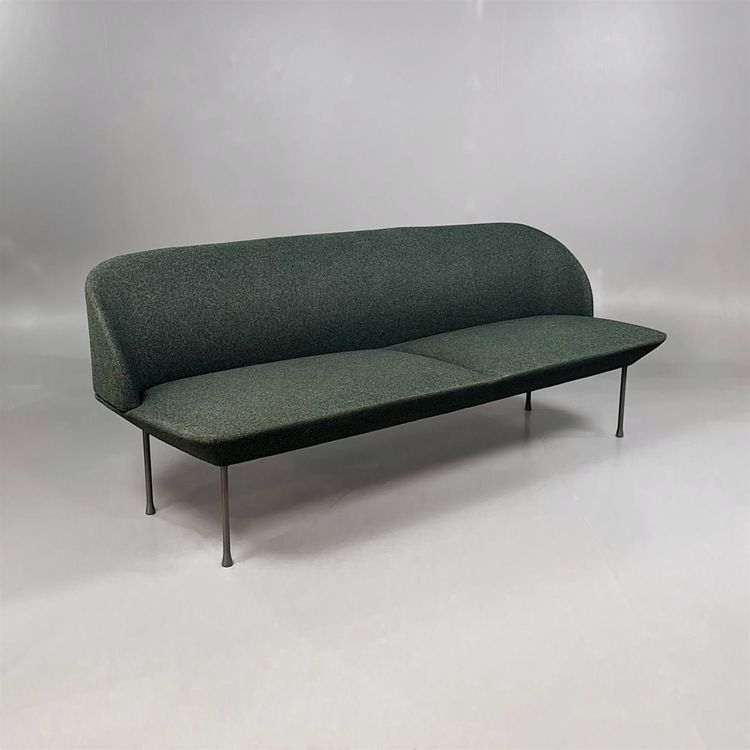 Begagnad soffa Oslo från Muuto. Klädsel i djupt mörkgrön tyg, ben i svart metall. Mått: bredd 200 cm, djup 73 cm och höjd 78 cm. 