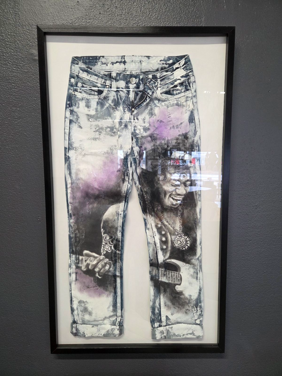 Begagnad tavla designad av Lisa Löwenberg. Motivet visar Jimmy Hendrix på äkta jeansmaterial. Mått är höjd på 100 cm och bredd på 60 cm.
