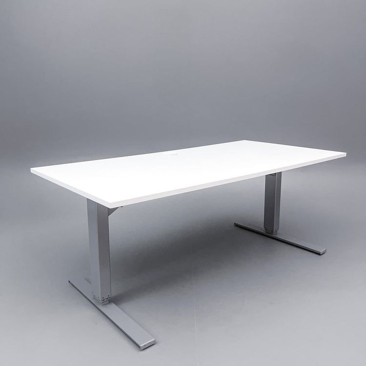 Begagnat höj och sänkbart skrivbord i vitt med stativ i silver, och kabeldike. Mått: bredd 160 cm, djup 80 cm, justerbar höjd 70 - 120 cm. 