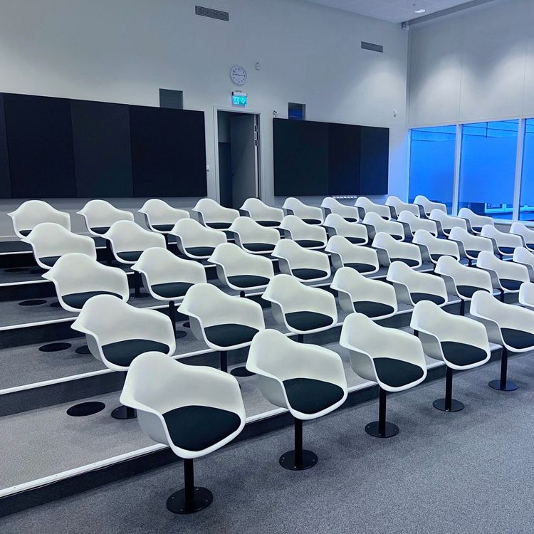 Begagnad konferensstol Eames Plastic Armchair från Vitra i vitt plastskal, svart tygsits och golvmonterat stativ i svart stål. Mått: Bredd 62,5 cm, djup 60 cm, höjd 83 cm.