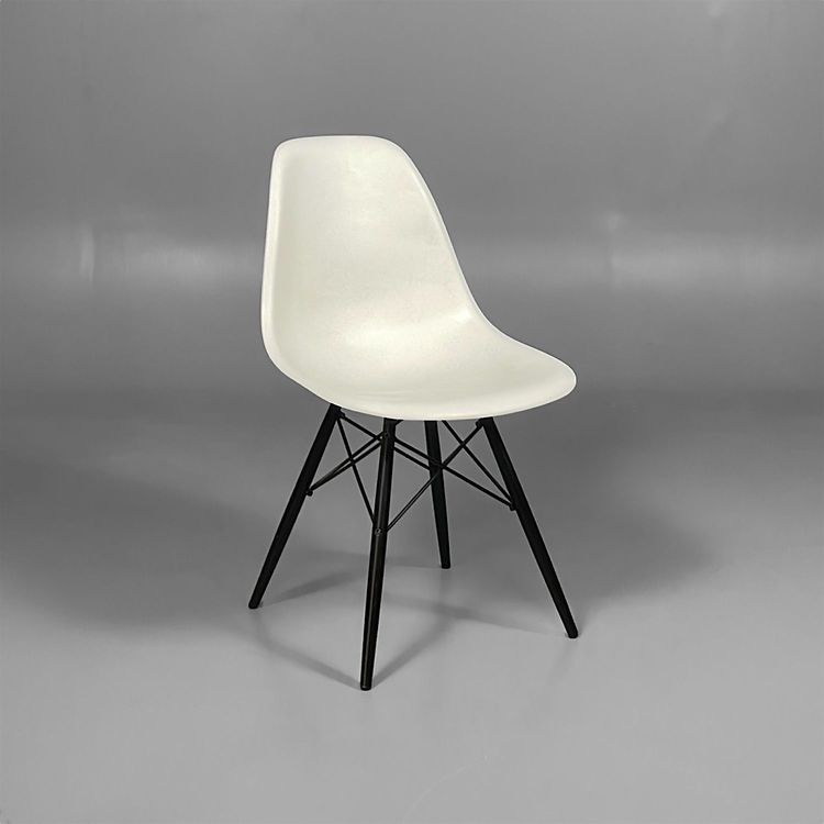 Begagnad matstol Eames Plactic Chair DSW från Vitra med vit sits och svarta träben. Mått: Bredd 46,5 cm, Djup 55 cm, Höjd 83 cm.