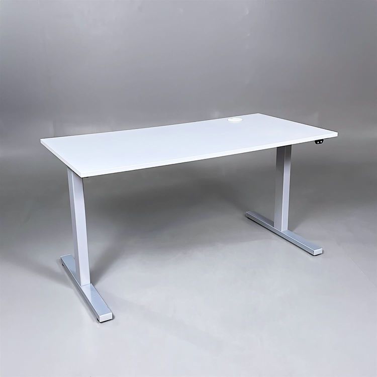 Begagnat höj- och sänkbart skrivbord. Bordsskiva är ljusgrå med stativ i silver. Mått: Bredd 140 cm, Djup 70 cm, justerbar höjd mellan 70 till 120 cm. 