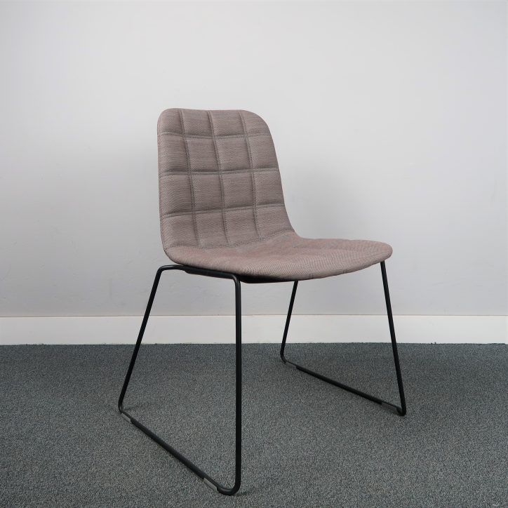 Stol Bop från Offecct på svarta medar klädd i brungrått tyg med insydda fyrkanter, utan armstöd.