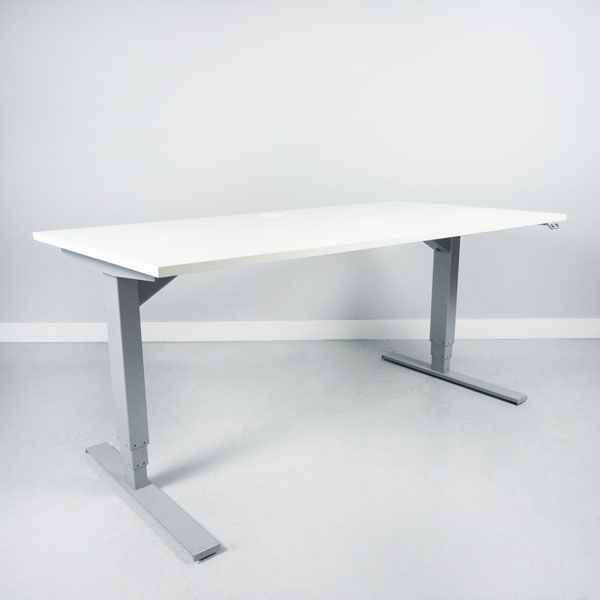 Begagnat höj och sänkbart skrivbord, med rektangulär vit bordsskiva och silvrigt stativ. Mått: Bredd: 160 cm, Djup: 80 cm, Justerbar höjd: 70–120 cm. 