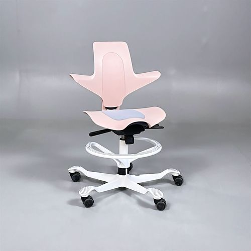 Begagnad kontorsstol med sadelsits från HÅG, modell Capisco Puls 8010. I rosa med grå dyna och vitt stativ. Mått: Justerbar sitthöjd mellan 47 till 56 cm. 
