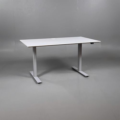 Begagnat höj- och sänkbart skrivbord med vit färgad bordsskiva och silvrigt stativ. Mått: Bredd 140 cm, djup 80 cm, justerbar höjd från 70 till 120 cm. 