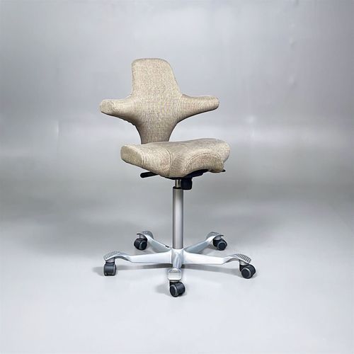 Begagnad kontorsstol med sadelsits från HÅG modell Capisco 8106. Beige tygklädsel och silverfärgat underrede. Mått: Justerbart sitthöjd mellan 60 till 85 cm. 