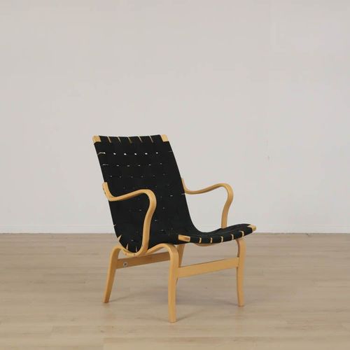 Begagnad fåtölj från Bruno Mathsson, modell Mi 472 Eva. Sits i svart sadelgjord och benen i bok, Mått: totalhöjd 81cm, sitthöjd 37.5 cm, Sittbredd: 49 cm, Sittdjup: 42 cm. 