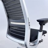Begagnad kontorsgrupp från Steelcase med kontorsstol Think i mörkgrå/svart och höj-och sänkbart skrivbord Migration i vitt. Bredd 120 cm, Djup 60 cm. 