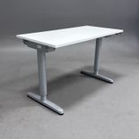 Begagnat höj- och sänkbart skrivbord från IKEA med vit bordsskiva och silverfärgat stativ. Mått: bredd 120 cm, djup 60 cm samt en justerbar höjd 70 - 120 cm. 
