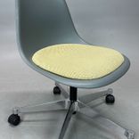Begagnad Vitra Eames Plastic Side Chair PSCC med grått plastskal, ljusgul sittdyna, kromat underrede och hjul. Mått: Bredd 46,5 cm, djup 55 cm, höjd 76–88,5 cm. 