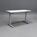 Begagnat höj- och sänkbart skrivbord från IKEA med vit bordsskiva och silverfärgat stativ. Mått: bredd 120 cm, djup 60 cm samt en justerbar höjd 70 - 120 cm. 